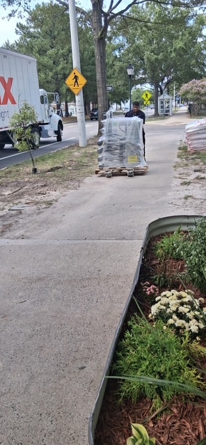 Volunteer moving pallet of supplies on sidewalk
