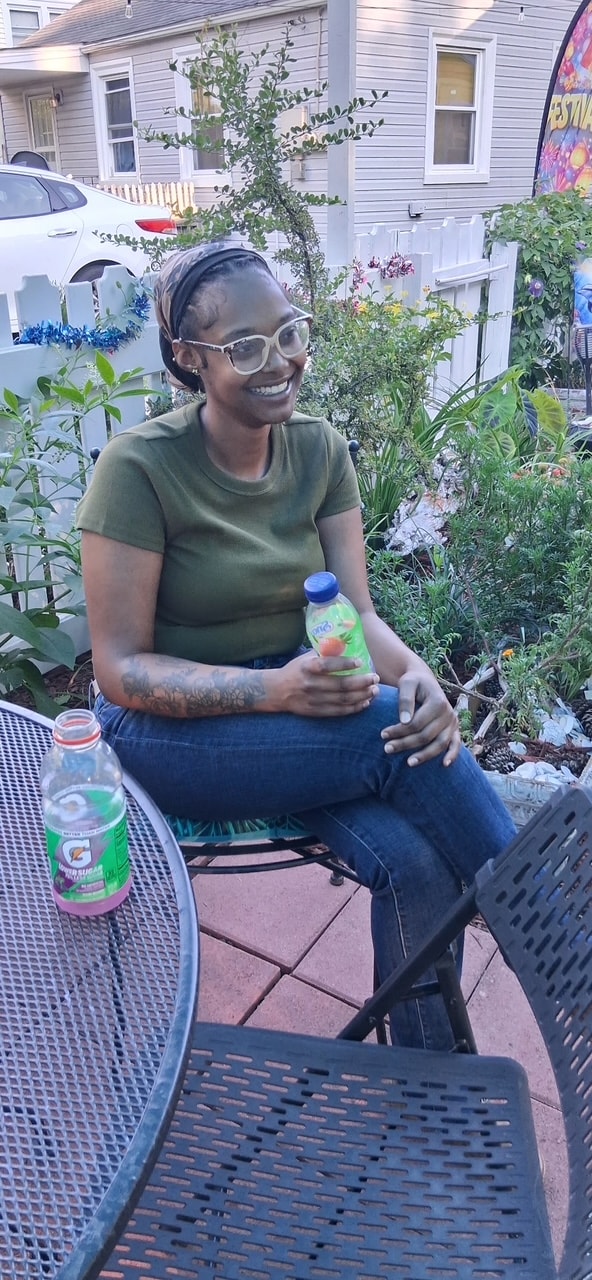 Volunteer smiling outdoors at community event